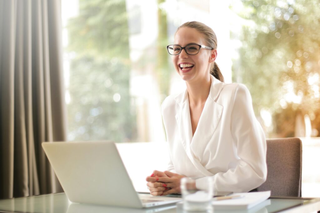 femme authentique souriante heureuse devant son portable